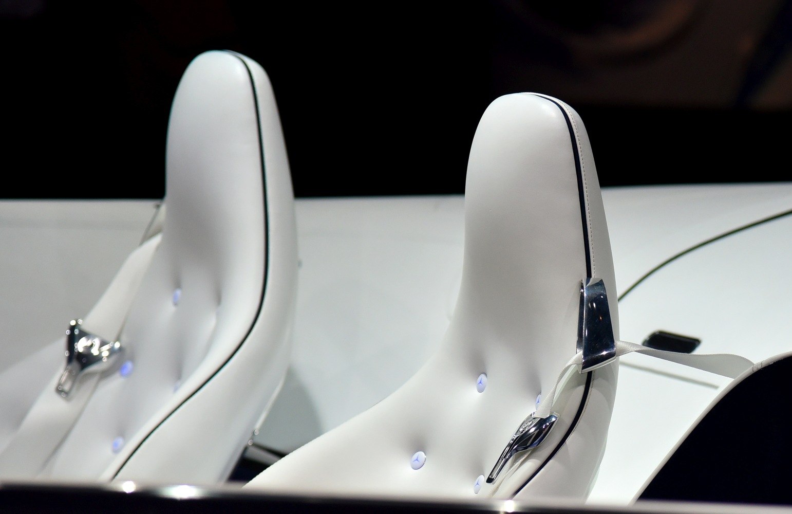 White leather seats with illuminated details and chrome seatbelt buckle