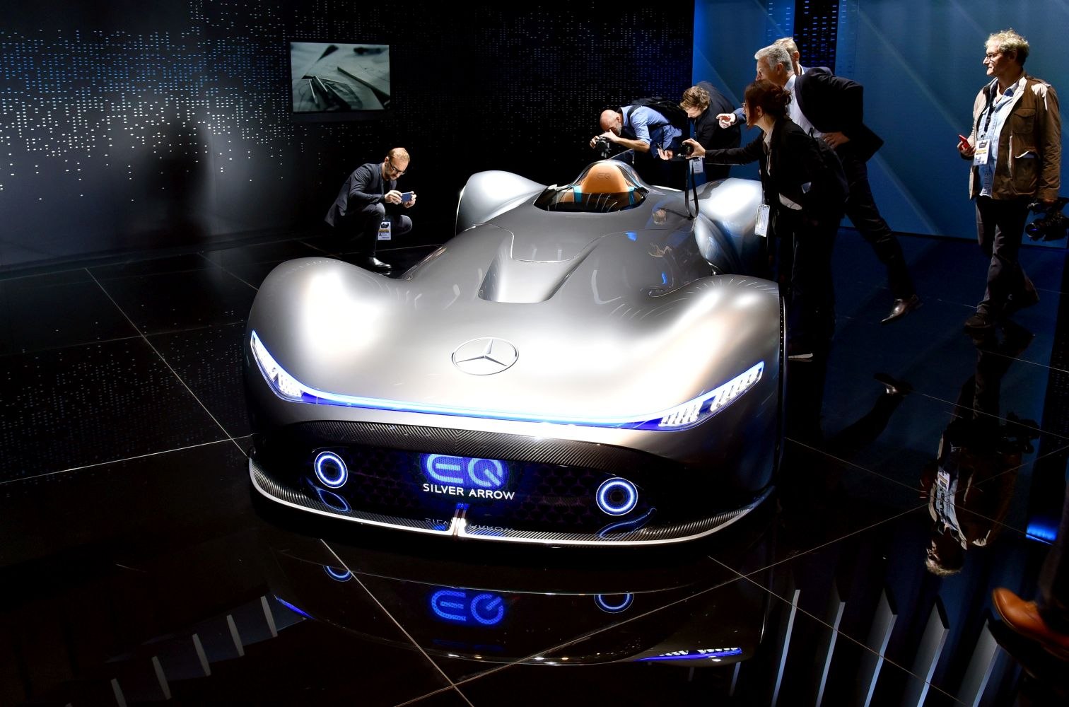 Sleek aerodynamic electric concept car with blue LED lights and single-seat cockpit.
