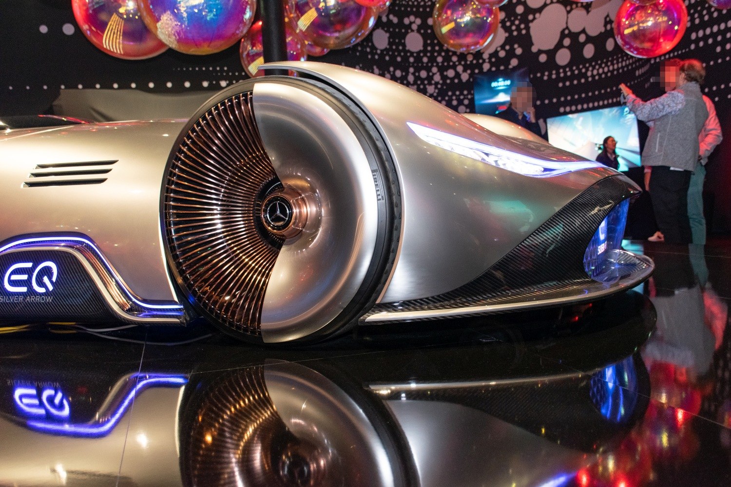Illuminated futuristic wheel and sleek LED headlight on a concept car.