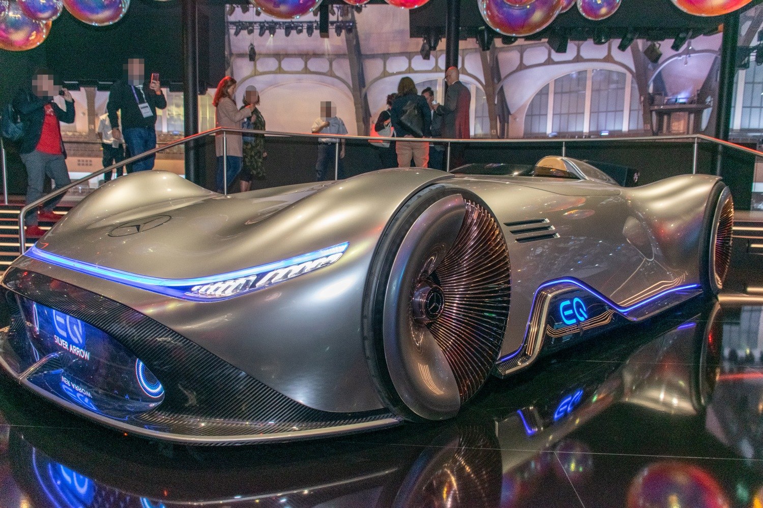 Streamlined electric vehicle with turbine-style wheels and blue lighting