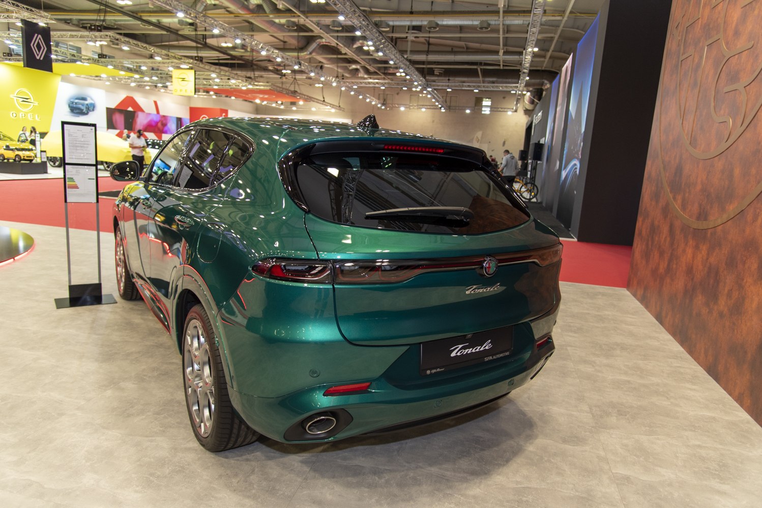 Rear view of green SUV with connected taillights and visible exhaust pipes