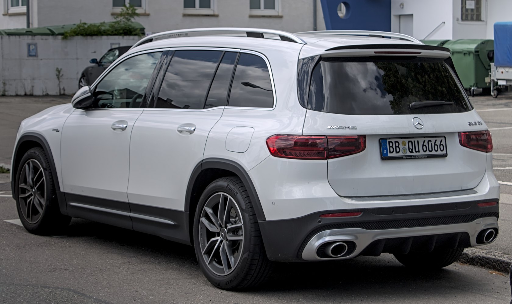 Rear and side profile of white SUV with AMG styling and dark taillights