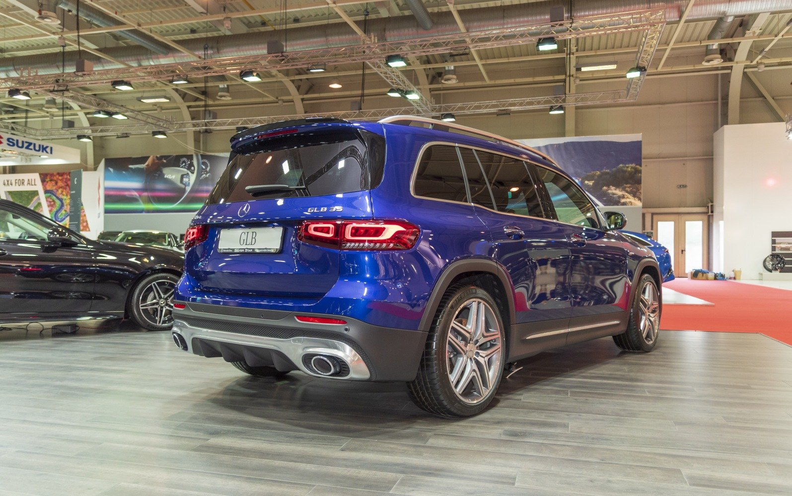 Rear of blue compact SUV with LED tail lights and dual exhaust.