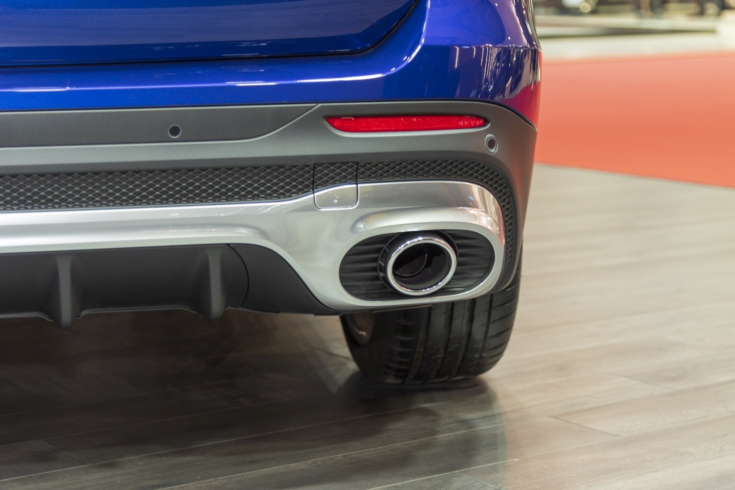 Rear exhaust pipe and bumper with reflector