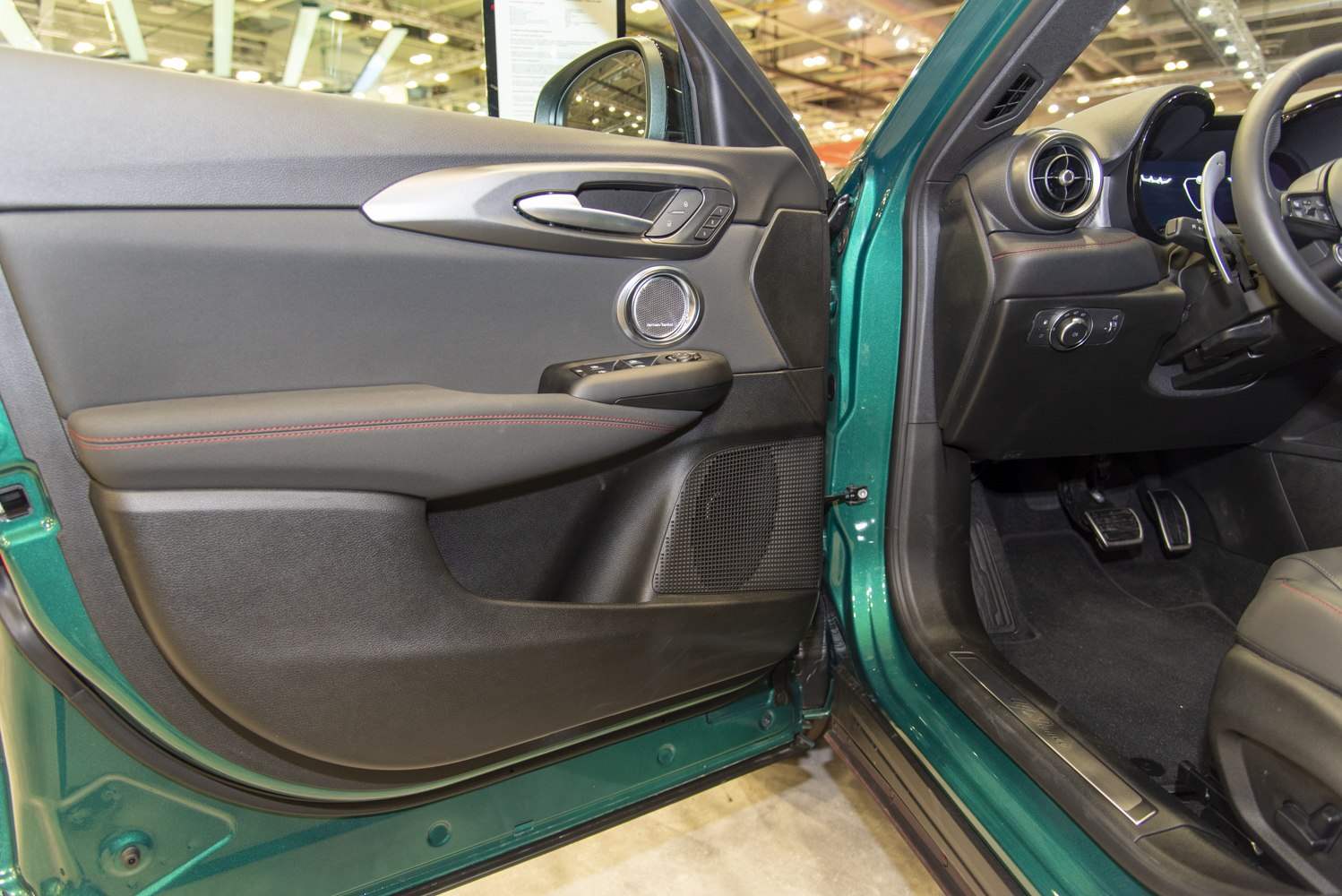 Interior door panel and dashboard with round air vent and speaker grille