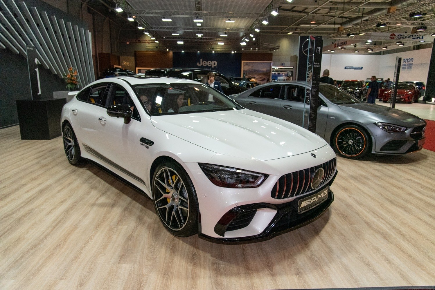Front and side view of a luxury four-door coupe with sporty alloy wheels and aggressive grille.