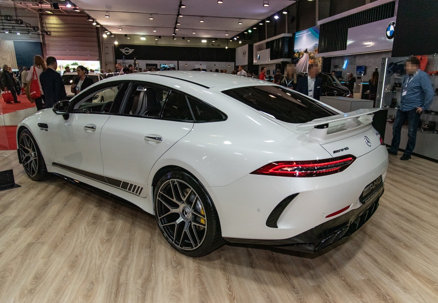 Rear side view with spoiler and sports rims of a luxury four-door coupe
