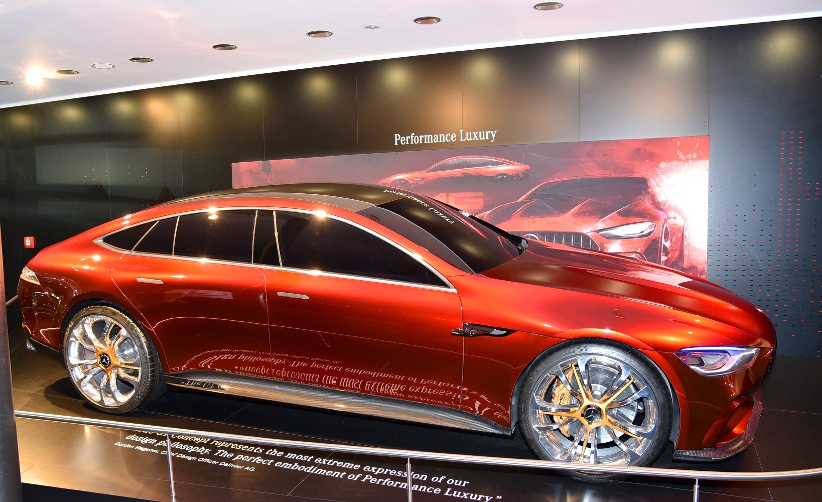 Sleek red 4-door coupe with large multi-spoke alloy wheels and chrome window trim