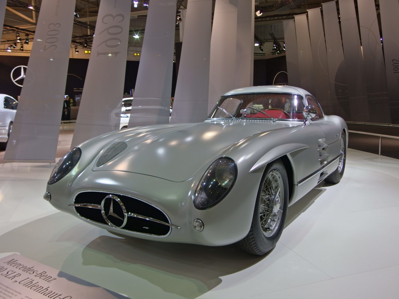Silver classic coupe with rounded headlights and wire-spoke wheels