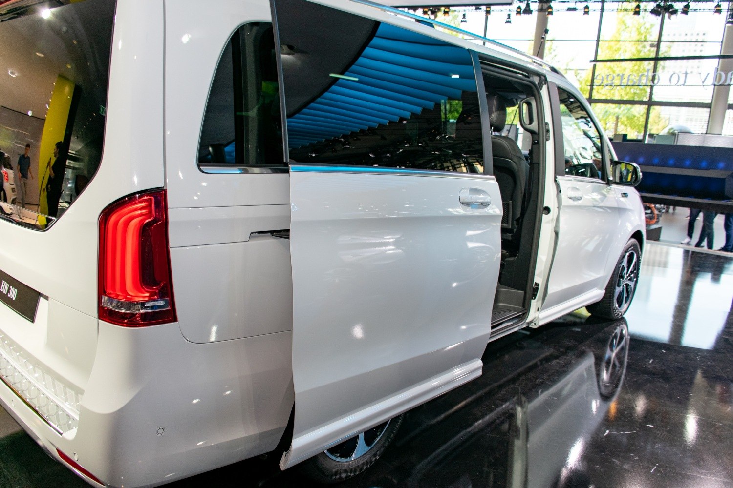 Sliding rear door and distinct rear light cluster on white electric minivan