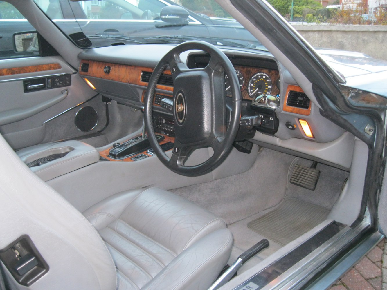 Wood-trimmed dashboard and leather driver's seat in vintage car interior