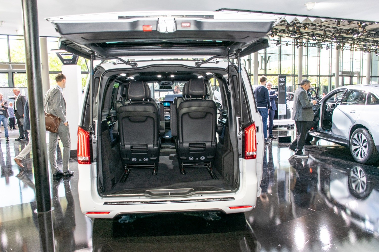 Open rear hatch with two black seats and spacious cargo area inside van
