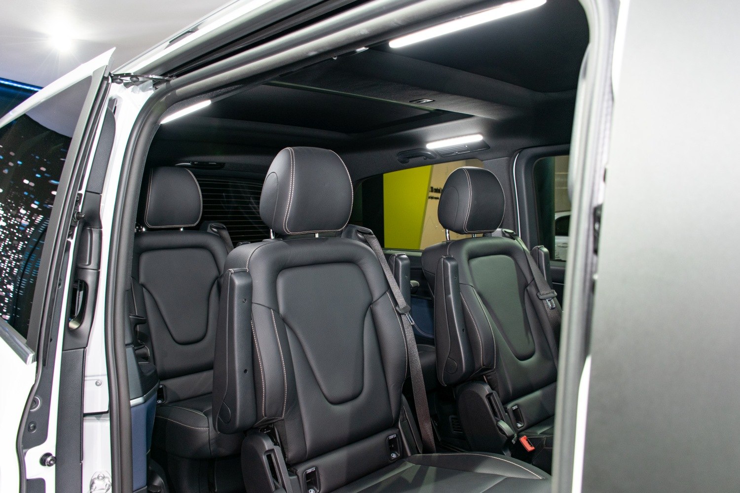 Luxury black leather multi-seat interior with adjustable armrests and seatbelts
