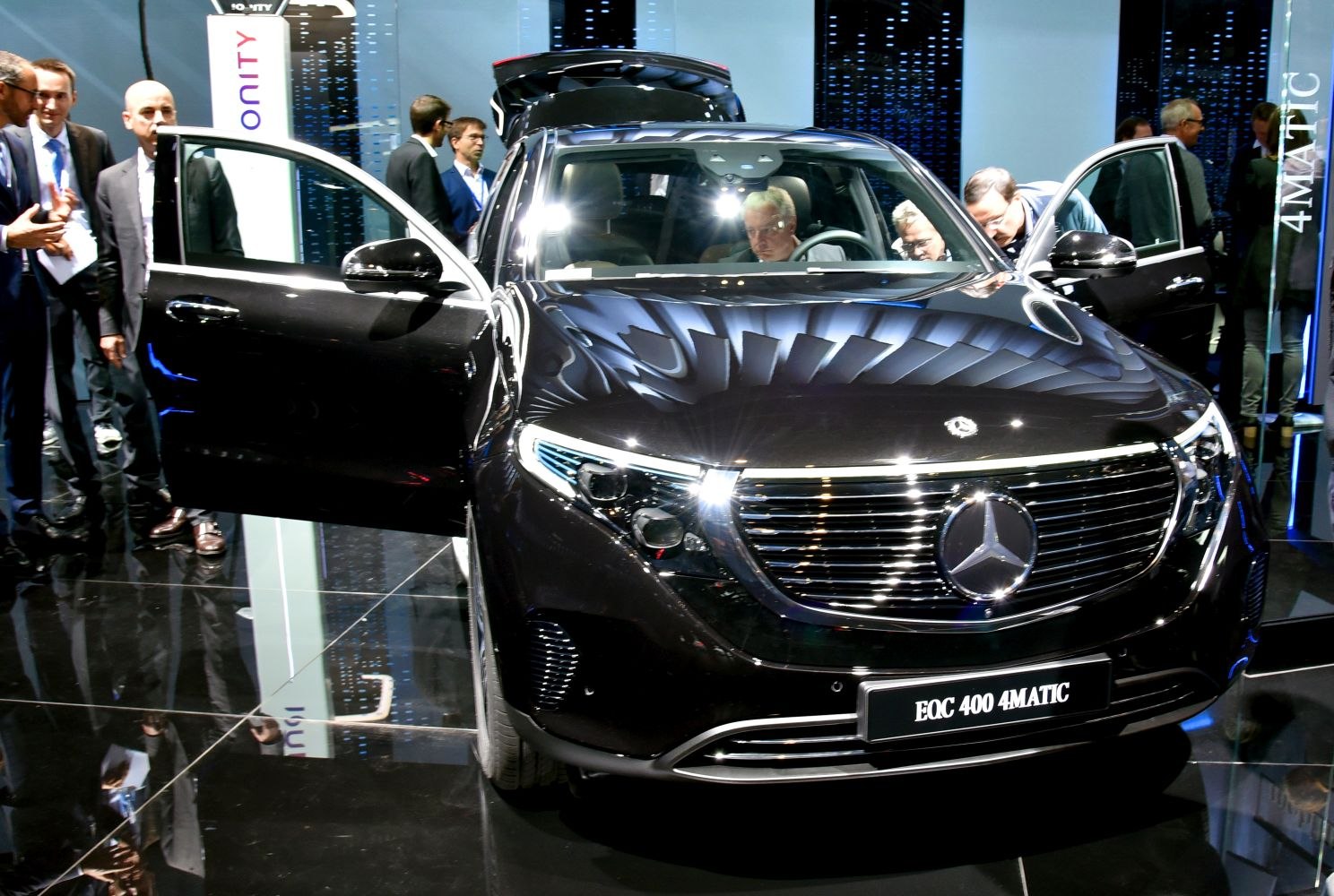 Front view of black electric SUV with open doors and illuminated headlights