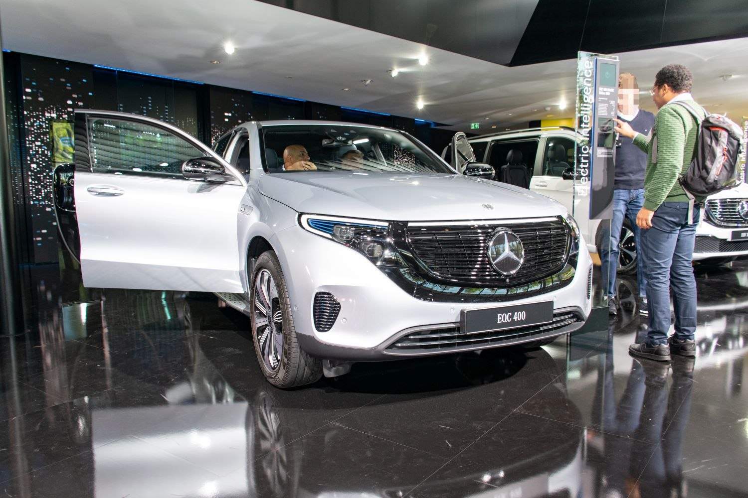 Front view of electric SUV with open front door in showroom