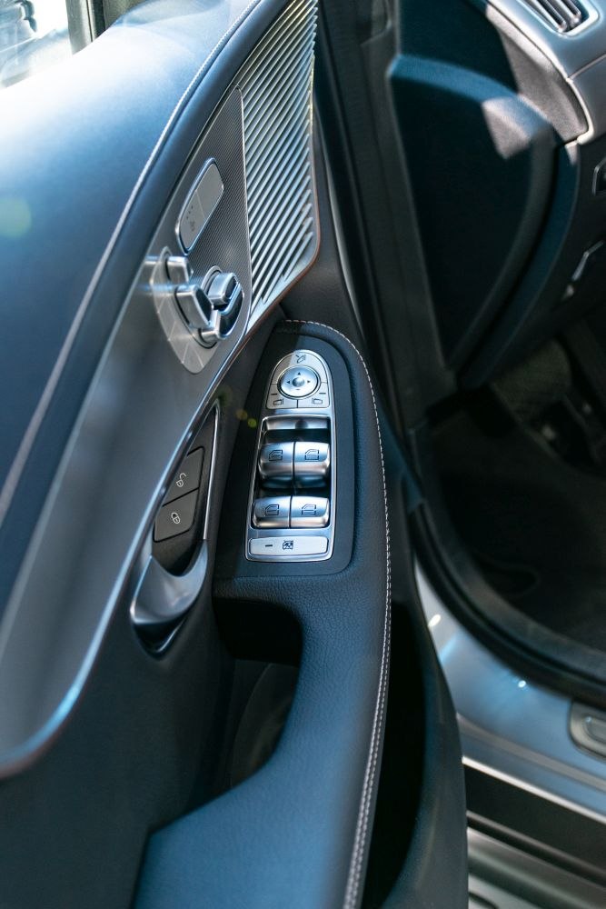 Detailed door panel with window and mirror controls on luxury car interior