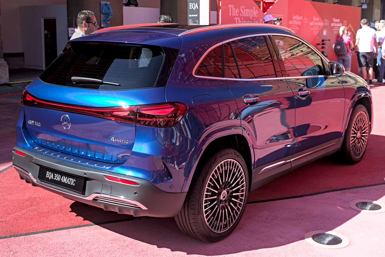 Rear side view of a blue modern electric SUV with LED light strip and multi-spoke alloy wheels