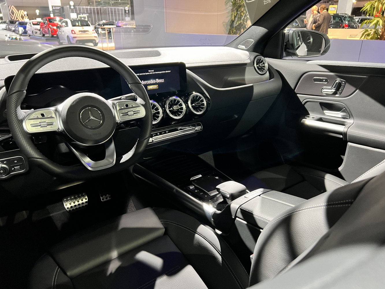 Steering wheel, digital dashboard, air vents, center console, car door panel
