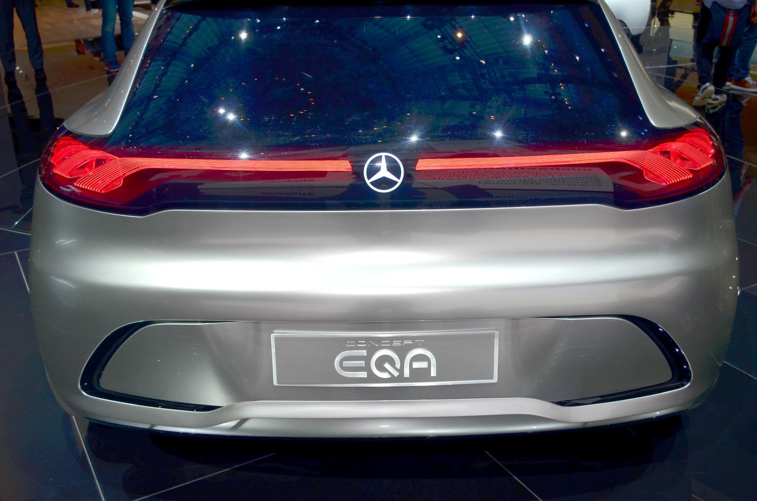 Sleek rear design with illuminated pattern tail lights and central emblem.