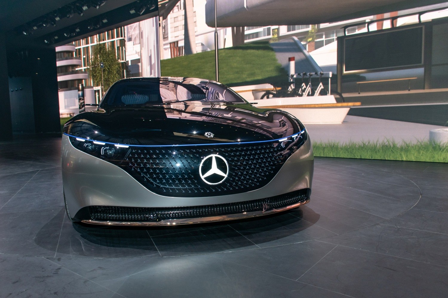 Illuminated grille and sleek LED headlights on futuristic vehicle front.