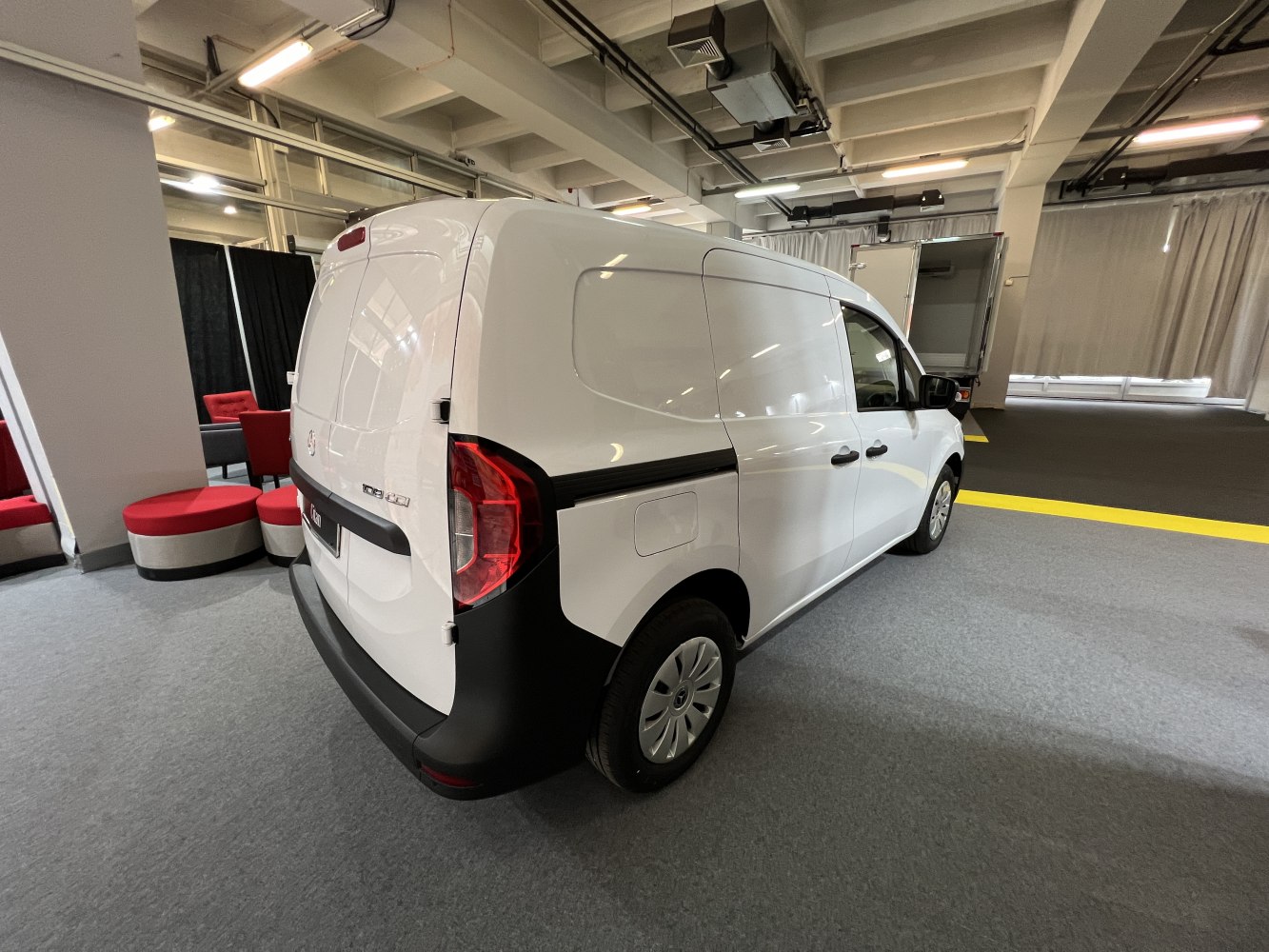 Rear and side view of a white panel van with smooth, spacious body panels.