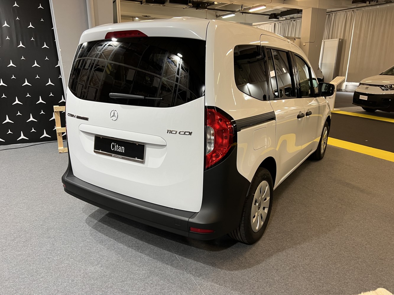 Rear view of a compact van with distinctive tail lights and large rear window