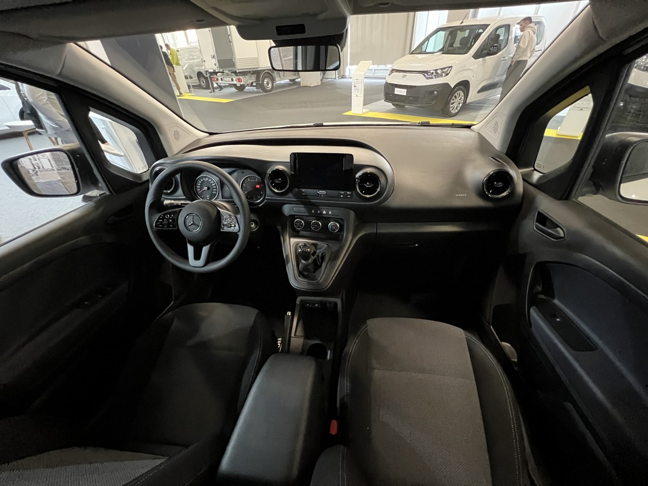 Modern dashboard and steering wheel interior with control panel and fabric seats