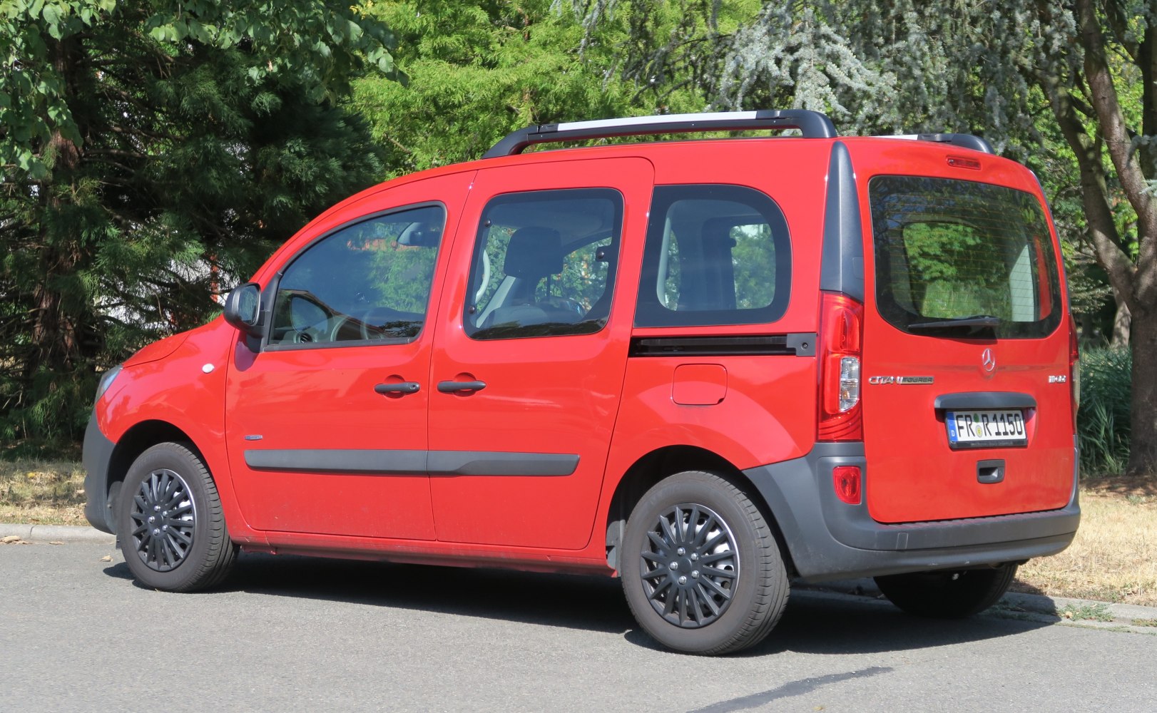 Red MPV with sliding doors and black wheels side view