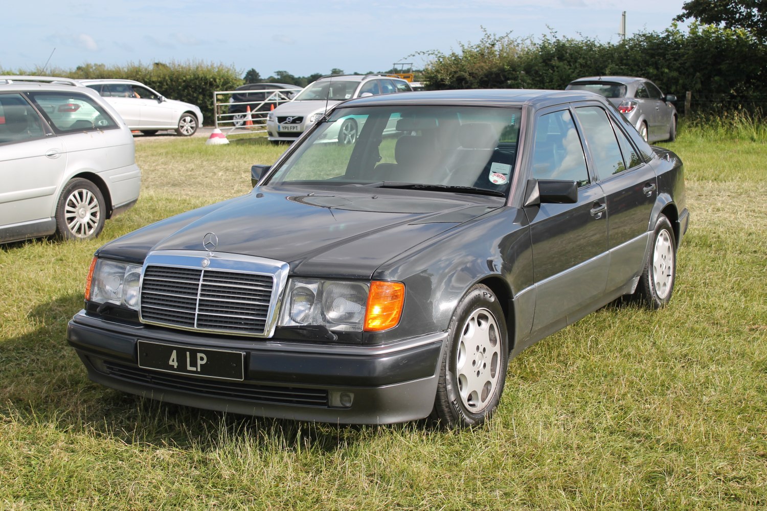 Four-door sedan with chrome grille, rectangular headlights, and alloy wheels.