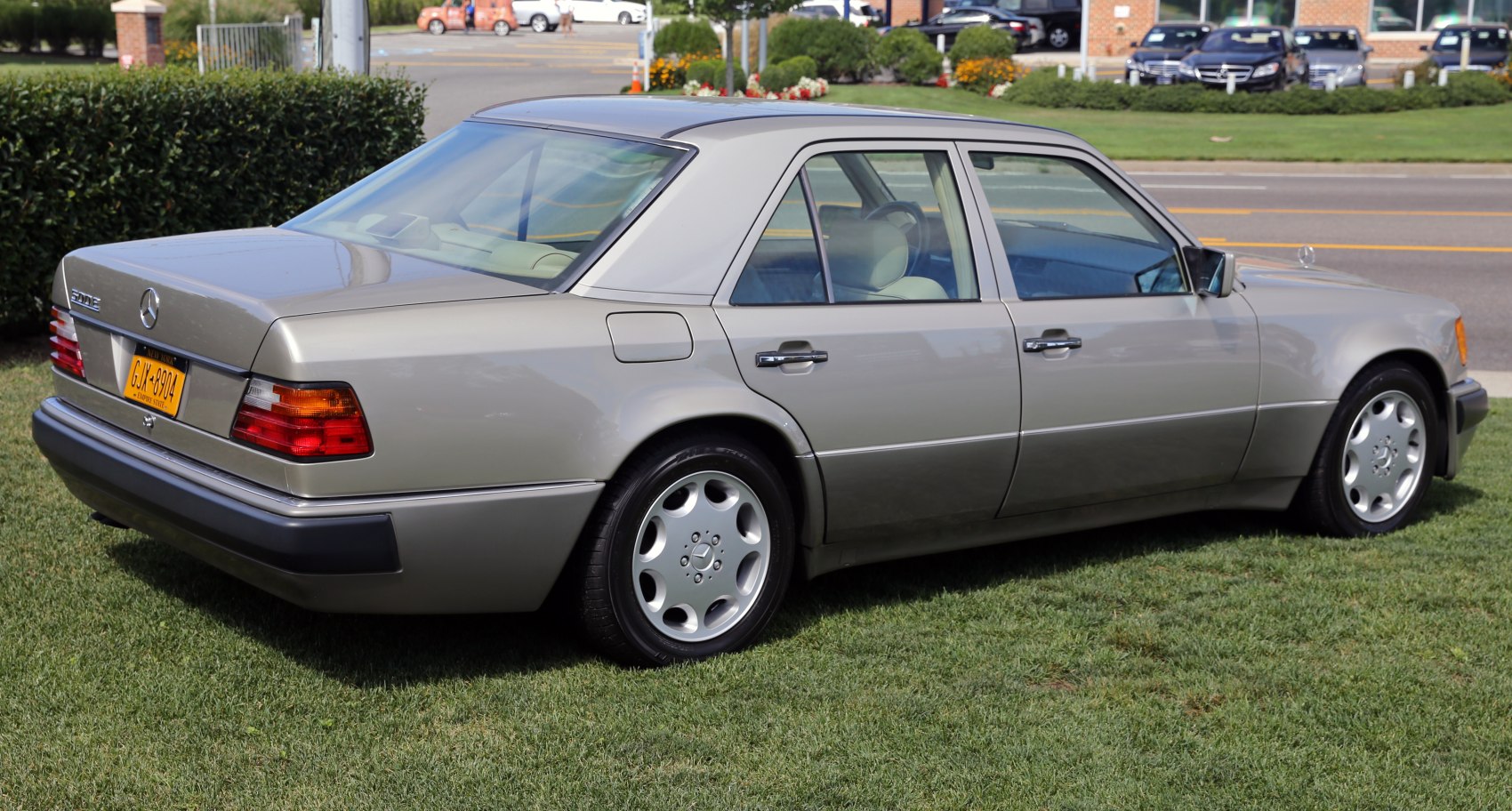 Silver sedan rear side profile with alloy wheels on grass