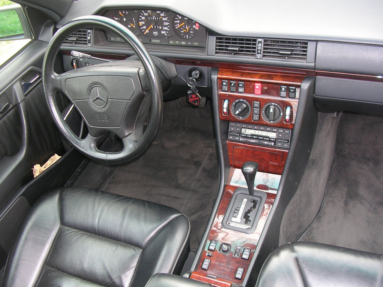 Classic car interior with dashboard, steering wheel, and wooden center console
