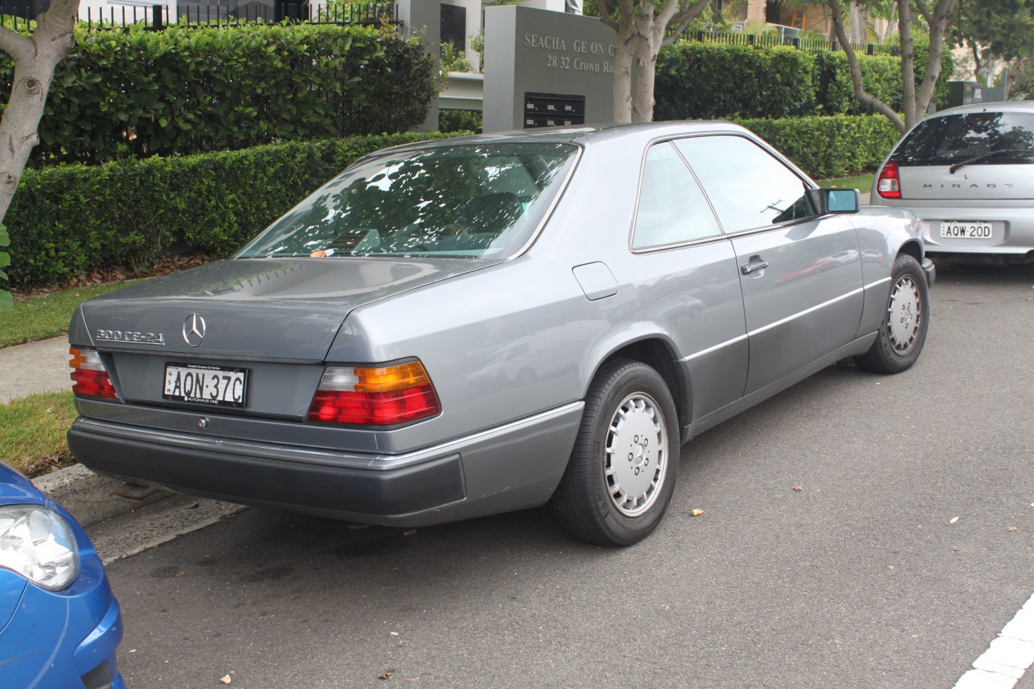 Vintage gray luxury coupe showing rear and side with classic taillights and two-door design