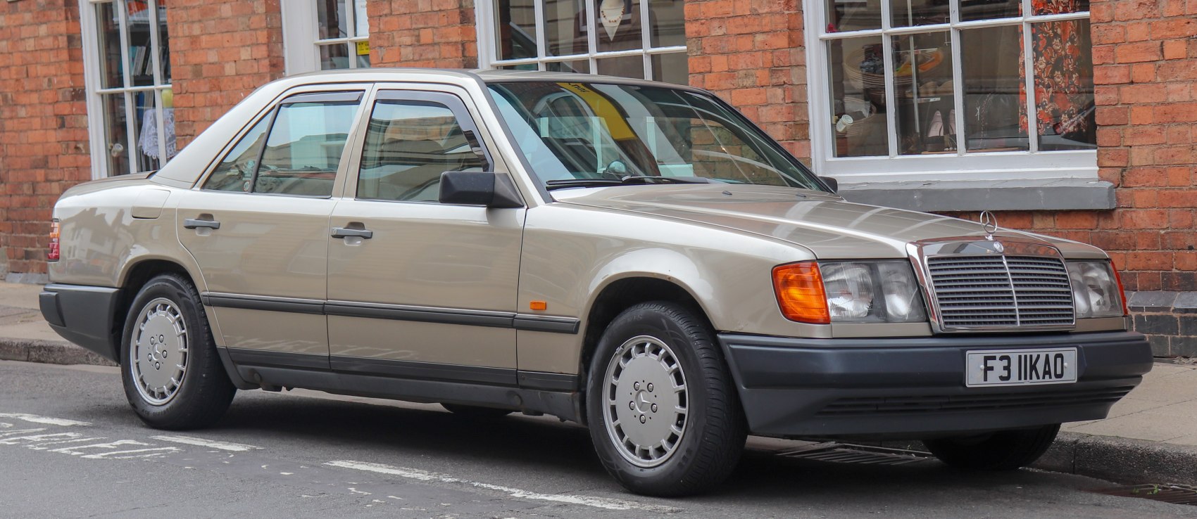Front side profile of a classic sedan with distinctive grille and vintage wheel design.