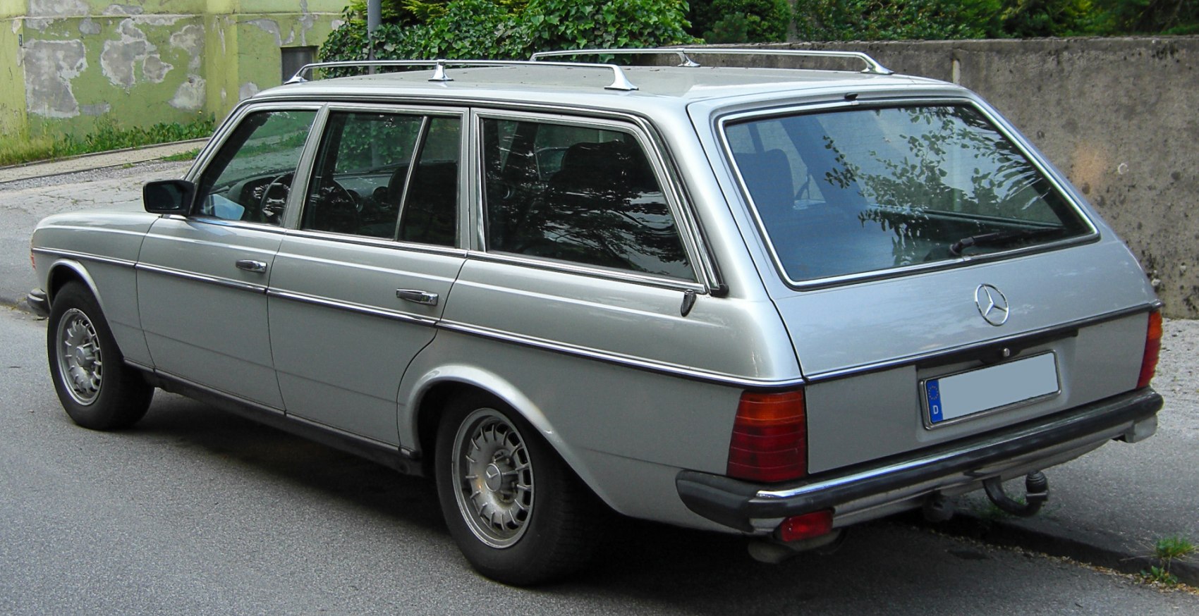 Vintage silver station wagon with roof rails and large rear window