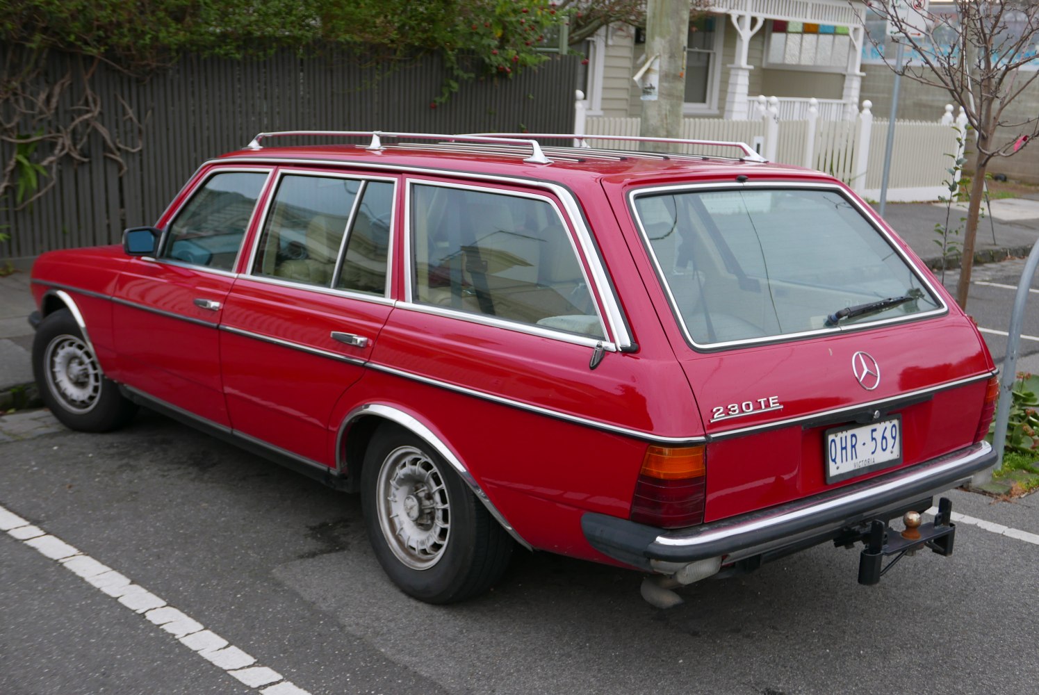 Red station wagon rear profile with roof rack and classic wheels