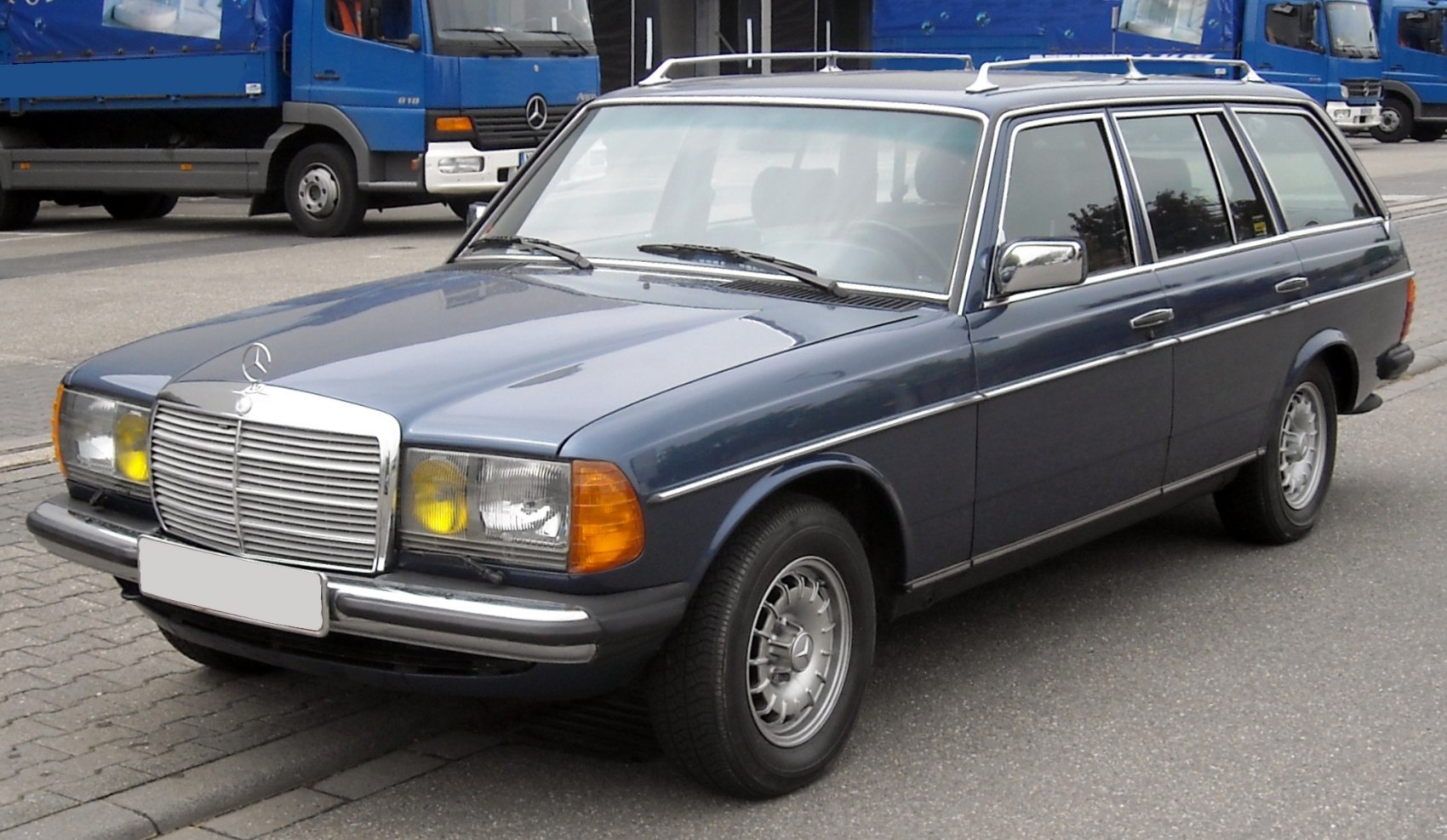 Vintage blue station wagon with chrome grille, yellow headlights, roof rails.
