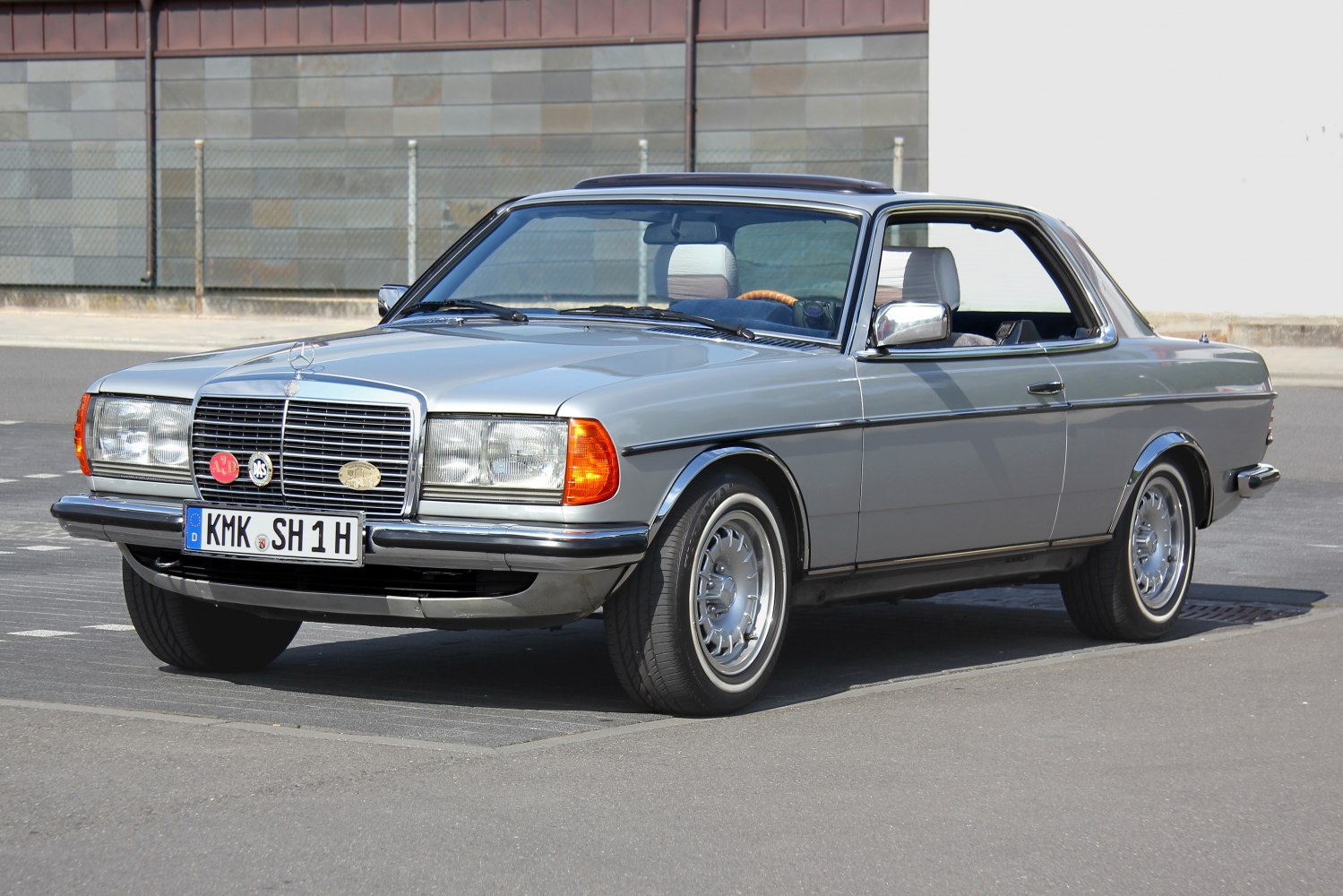 Vintage two-door silver coupé with chrome grille and classic wheels