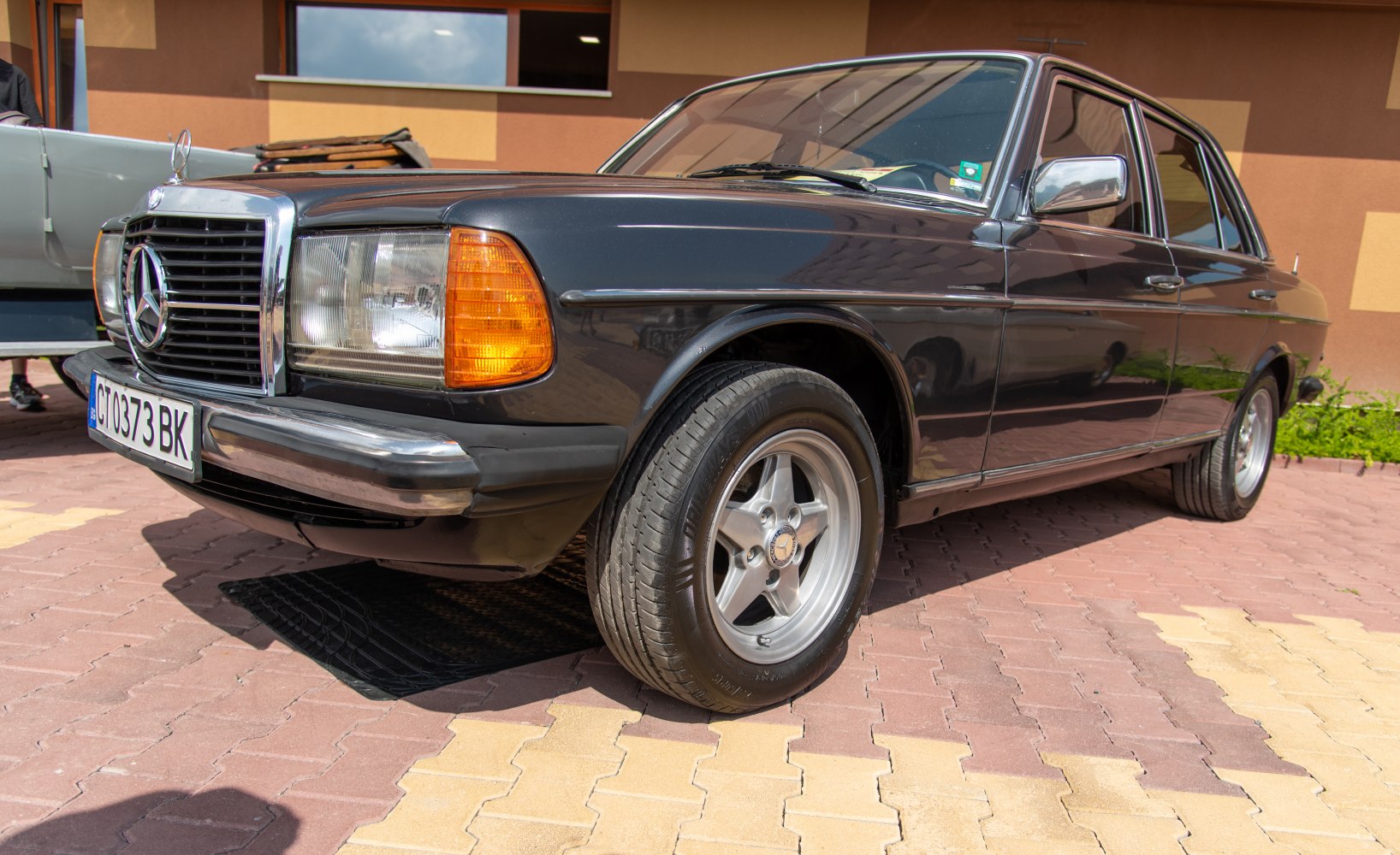 Front side view of vintage sedan with square headlights and alloy wheels