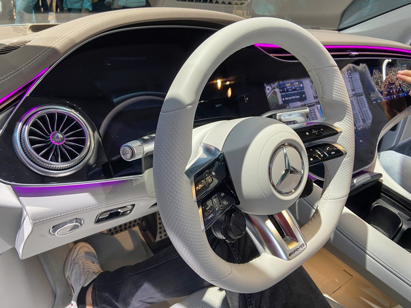 Luxury white AMG steering wheel with digital instrument cluster and ambient purple lighting