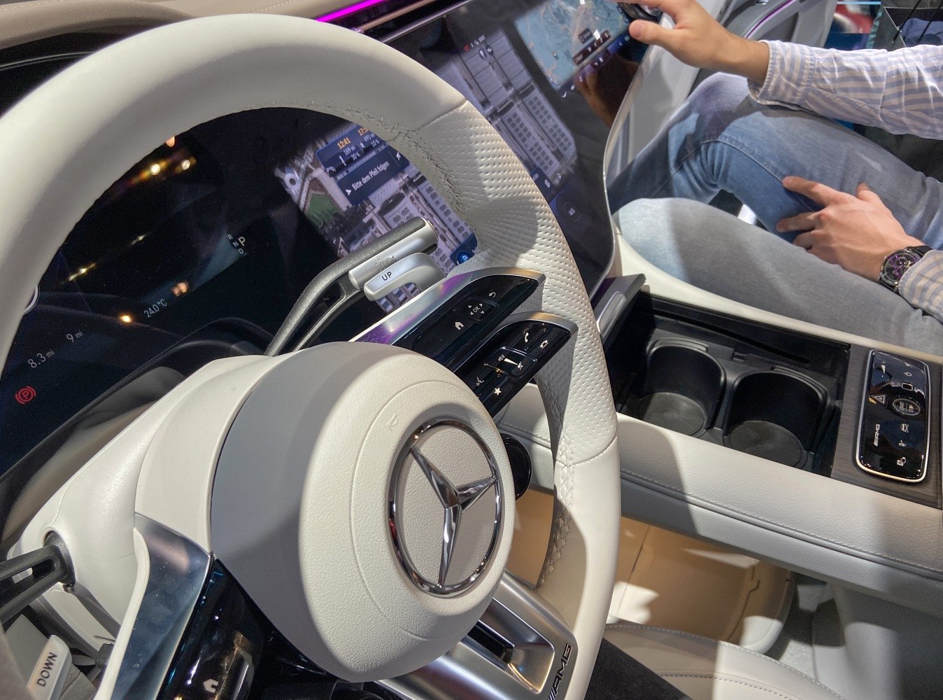 Luxurious white leather steering wheel with integrated digital controls and touchscreen center console