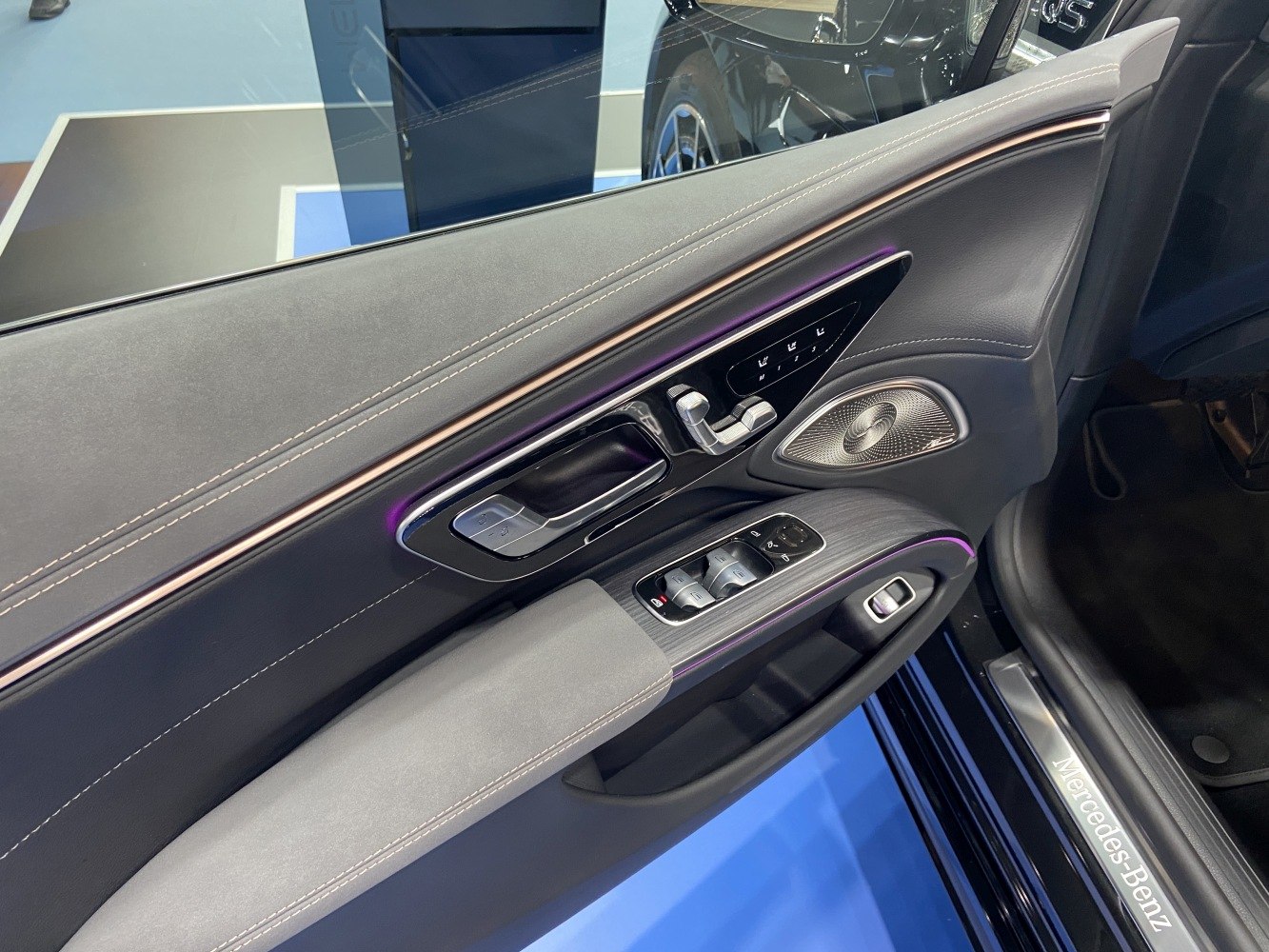 Premium car door panel with control buttons, speaker, and ambient lighting
