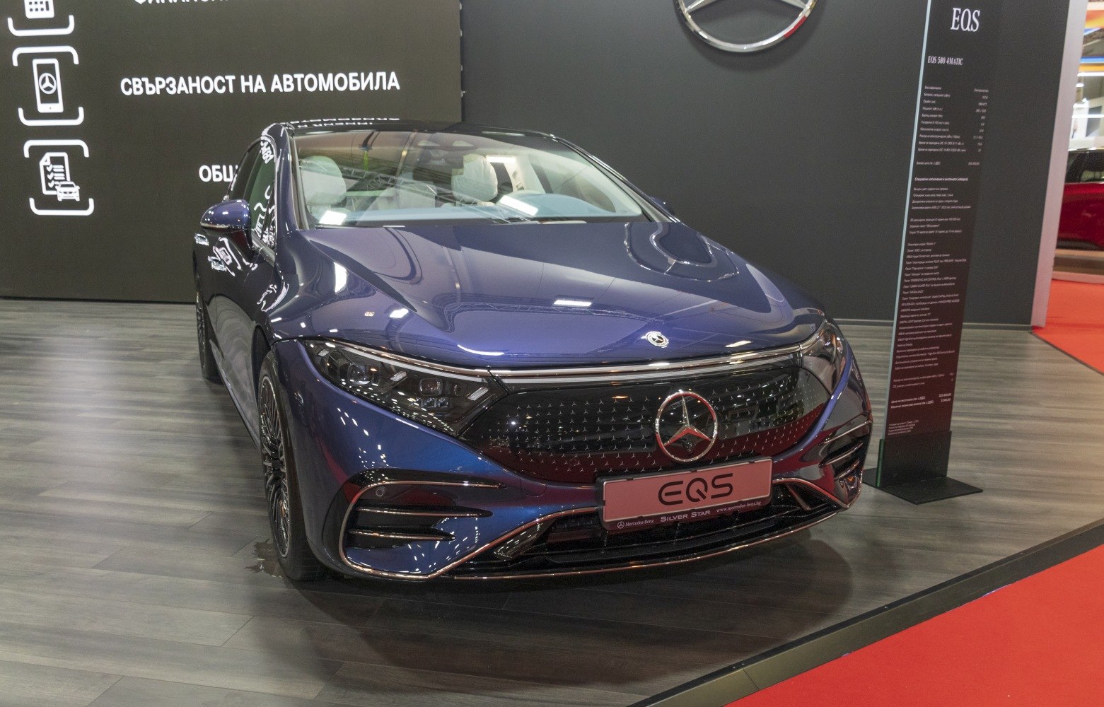 Front view of electric luxury sedan with LED headlights and illuminated grille
