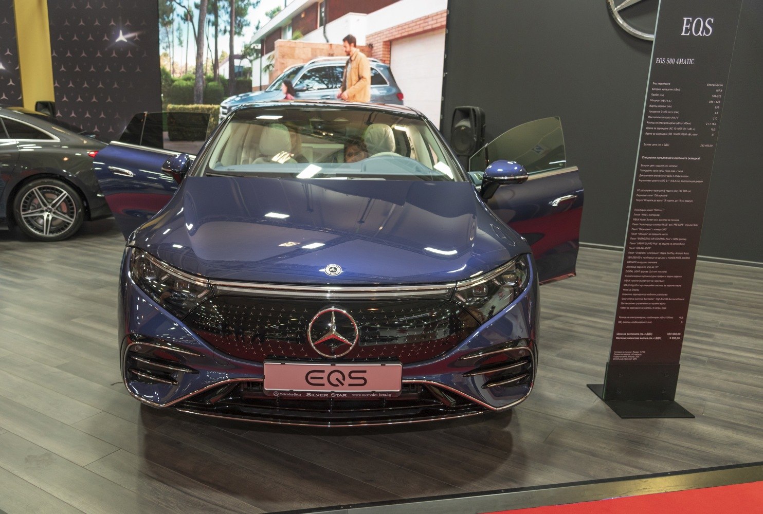 Front close-up of electric luxury sedan with LED headlights and unique grille design