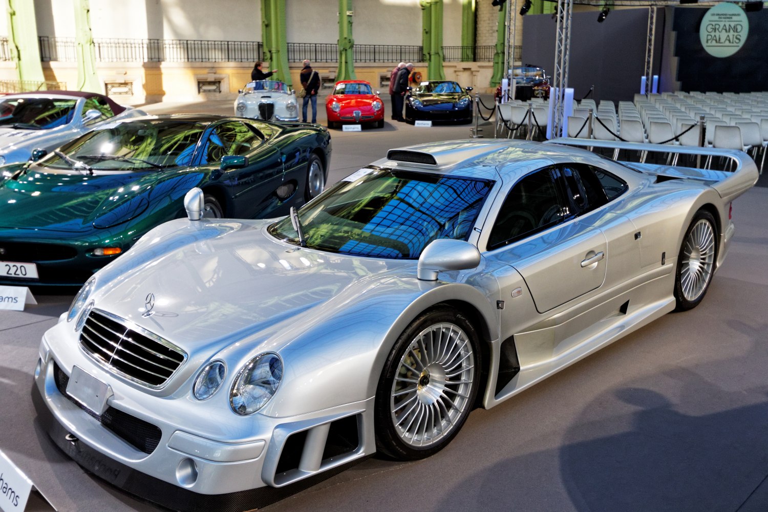 Silver aerodynamic sports coupe with large rear wing and vented bodywork.