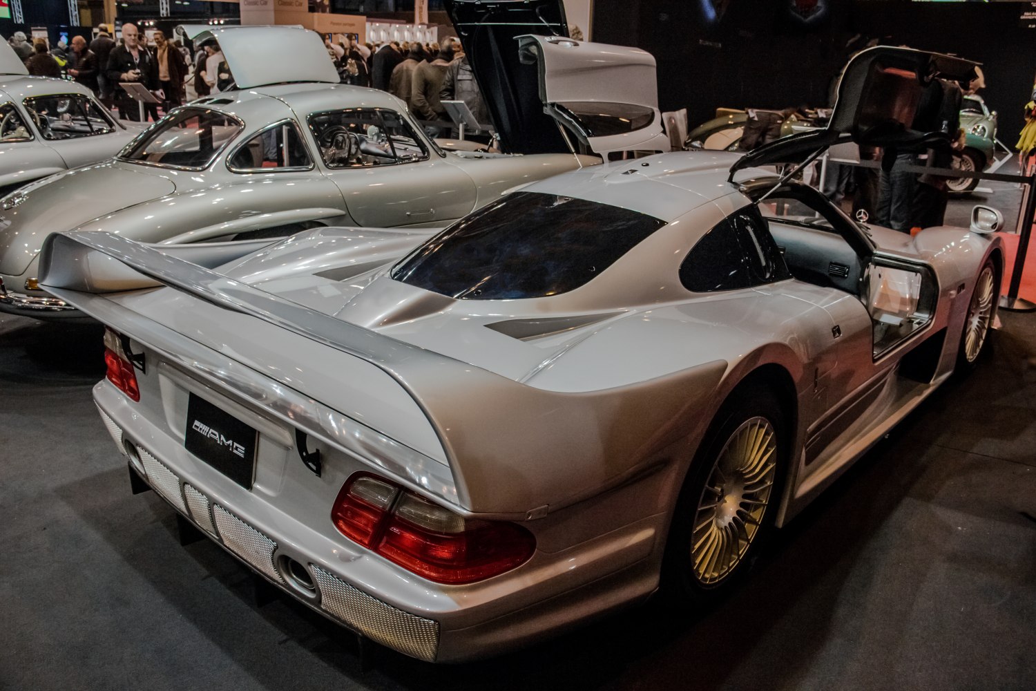 Silver supercar with rear wing and open gullwing doors