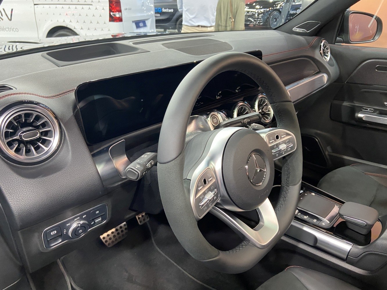 Steering wheel with controls and digital dashboard featuring circular air vents