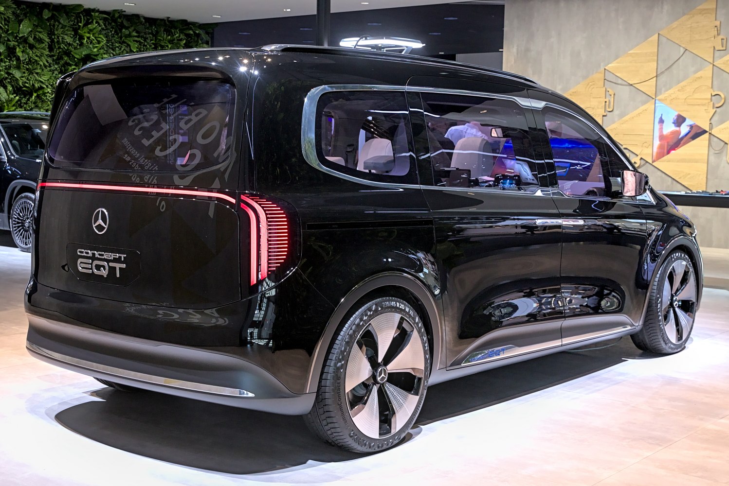 Rear and side view of a sleek futuristic electric van with LED taillights and aerodynamic wheels