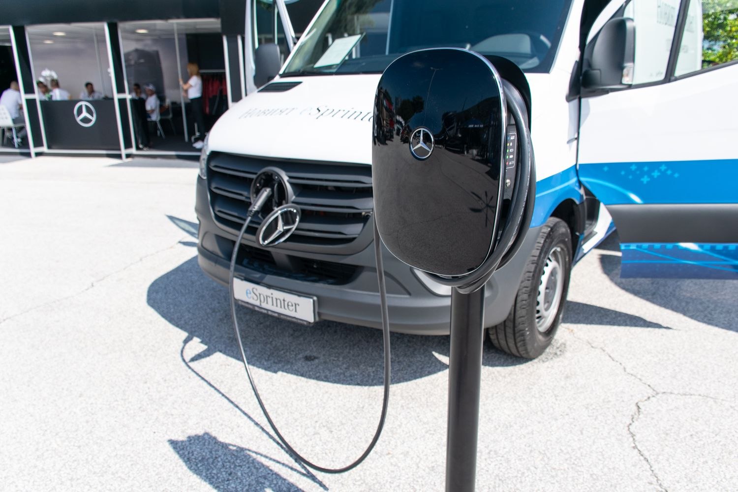 Electric vehicle charging station with front view of electric panel van and connected cable