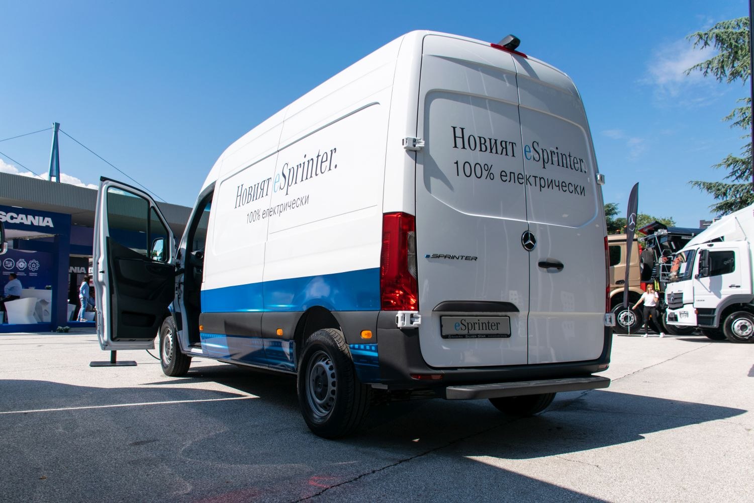 Rear and side view of electric panel van with open driver's door