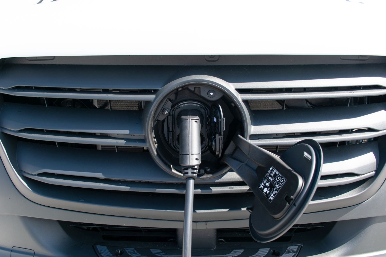 Front grille with electric charging port and cable connected.